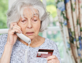 Senior Woman Giving Credit Card Details On The Phone